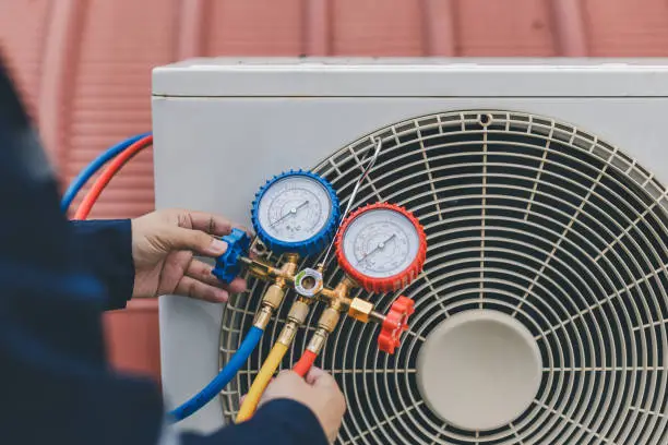 Experienced HVAC professional testing ventilation output and thermostat response in active building