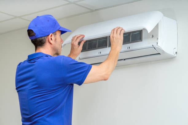 Installer checking thermostat calibration and airflow after complete central air replacement