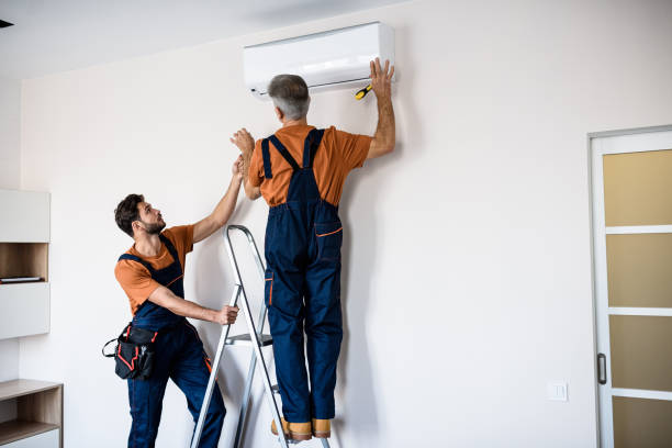 HVAC technician measuring airflow and inspecting connections on newly installed system