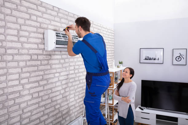 Technician replacing outdated air conditioner at occupied Great Neck family home