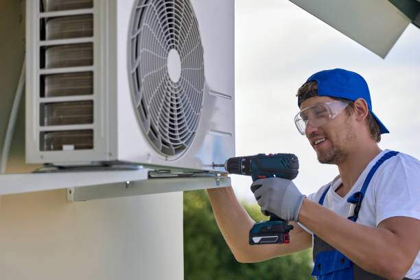 Installer setting outdoor AC unit beside Long Beach home before summer heat