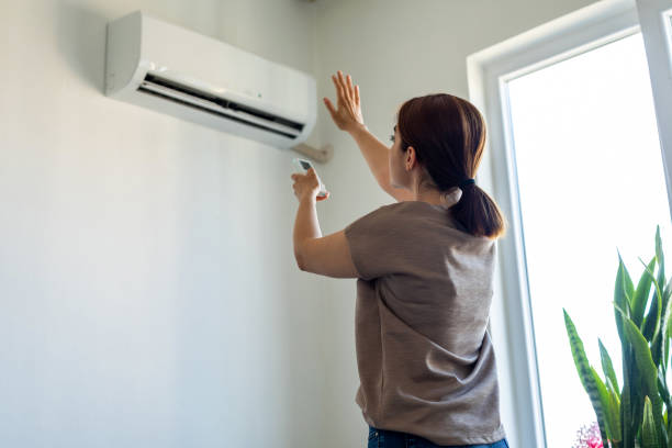 Experienced HVAC technician testing air conditioning components with gauges and diagnostic tools