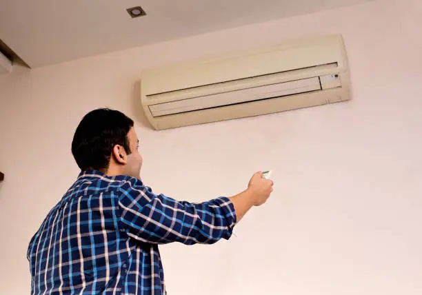 Technician checking AC performance at Great Neck home before weekend heat arrives