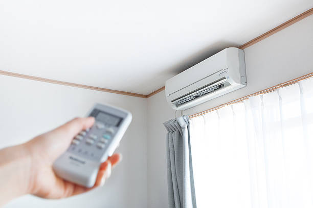 HVAC professional diagnosing residential cooling system performance with gauges and airflow testing
