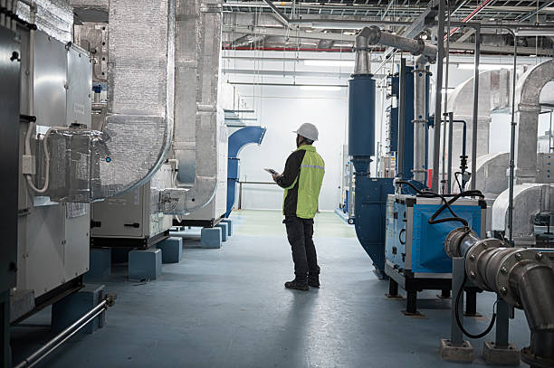 Experienced HVAC specialist testing commercial air distribution with diagnostic instruments indoors