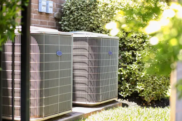 HVAC technician adjusting airflow settings inside busy Garden City office suite