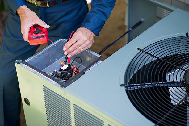 Technician performing HVAC maintenance in a residential Massapequa utility space