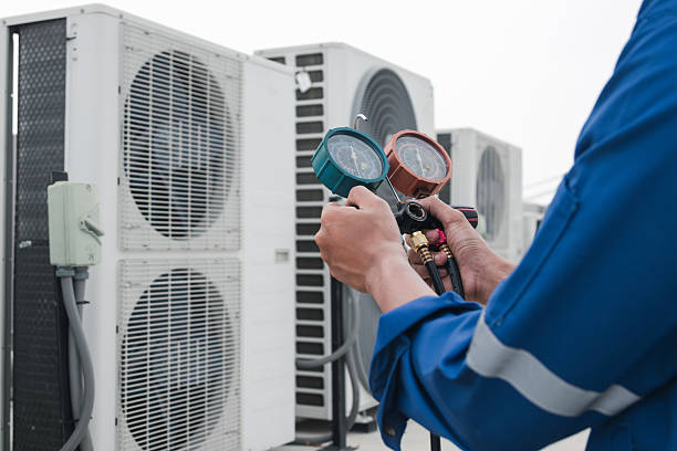 HVAC technician inspecting blower components and measuring system performance with diagnostic tools, Technician performing HVAC maintenance inside a Smithtown - NY utility room while testing system airflow