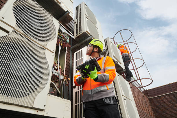 HVAC technician testing system performance and airflow with professional diagnostic tools, Commercial HVAC in Hempstead - NY with a technician checking rooftop units above a busy storefront